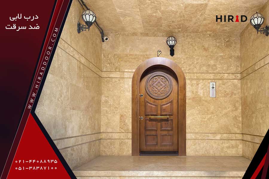 درب لابی ضد سرقت چوبی، گردویی رنگ به صورت حلالی، دارای یک قاب دایره شکل در قسمت بالای درب، دستگیره طلایی افقی در مرکز درب، نصب شده در لابی ساختمان لوکس